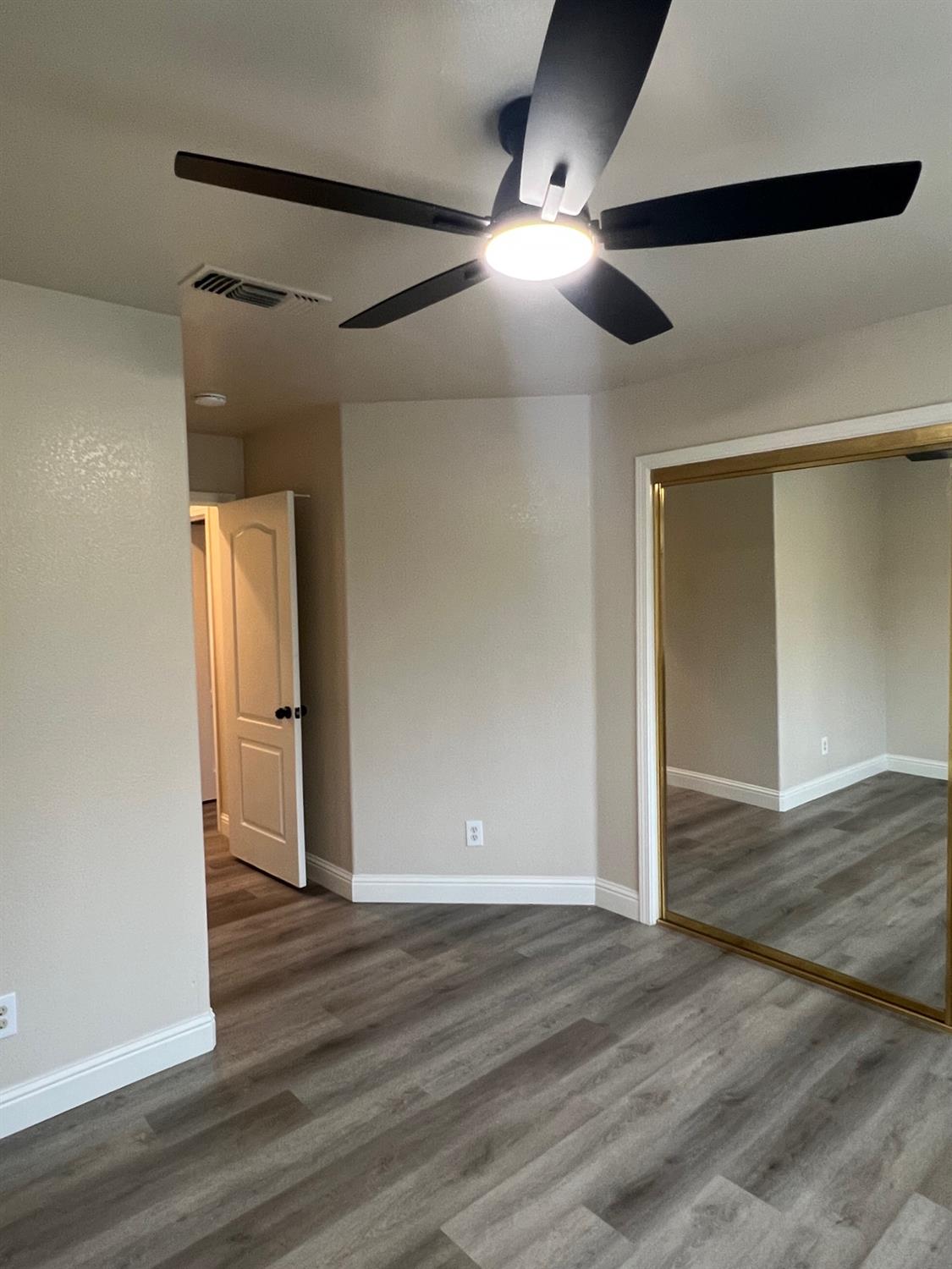 5930 West Birch Avenue Fresno, CA 93722 - Photo 26 of 32 an empty room with wooden floor and windows