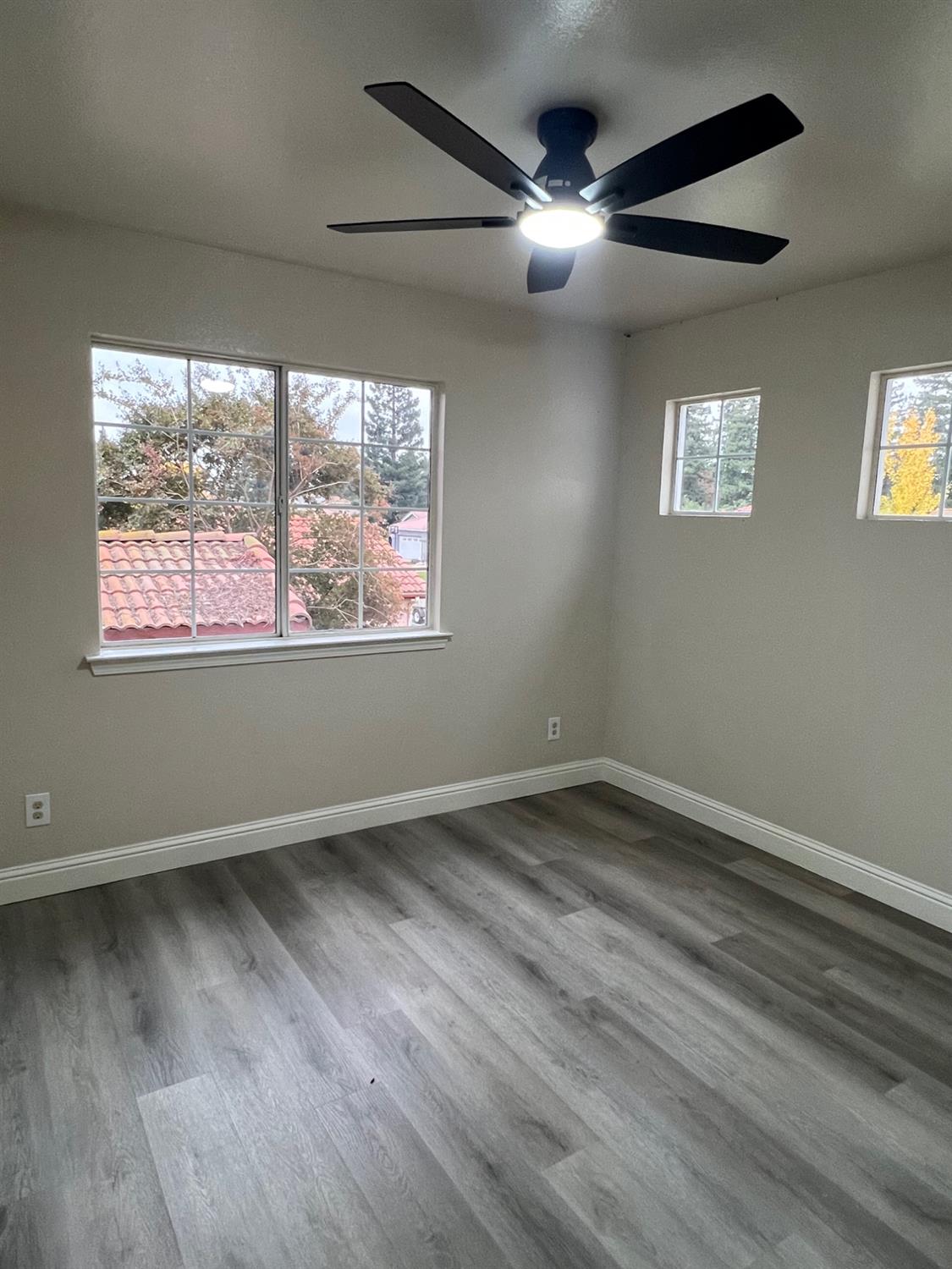 5930 West Birch Avenue Fresno, CA 93722 - Photo 27 of 32 an empty room with wooden floor fan and windows