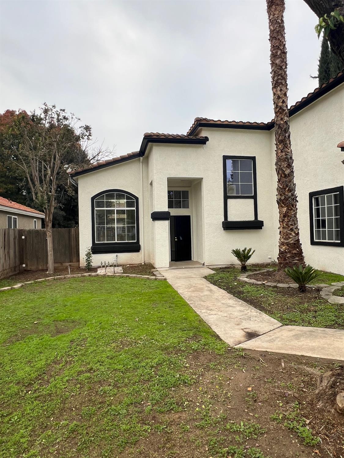 5930 West Birch Avenue Fresno, CA 93722 - Photo 3 of 32 a front view of a house with a yard and garage