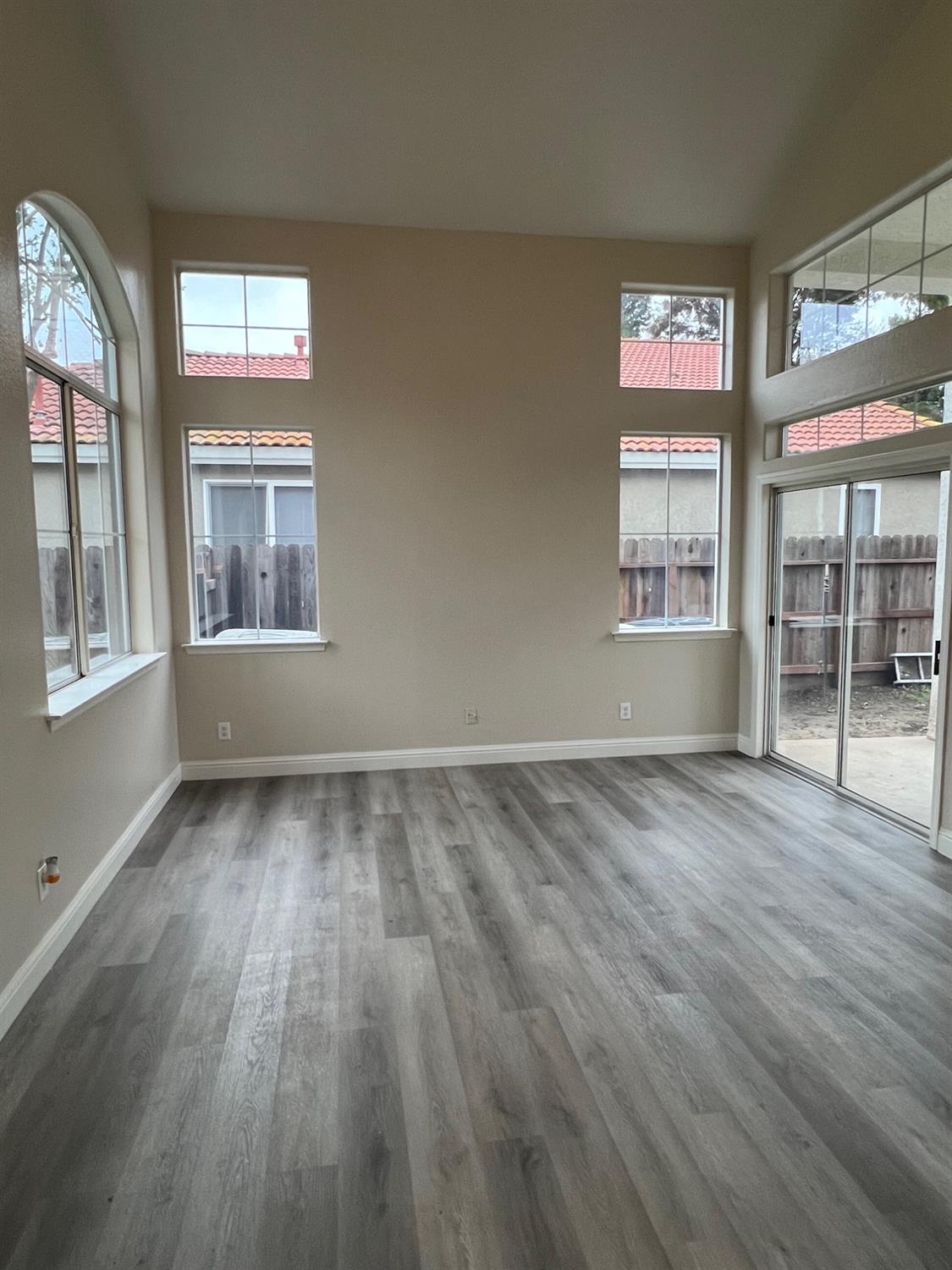 5930 West Birch Avenue Fresno, CA 93722 - Photo 4 of 32 an empty room with wooden floor and windows