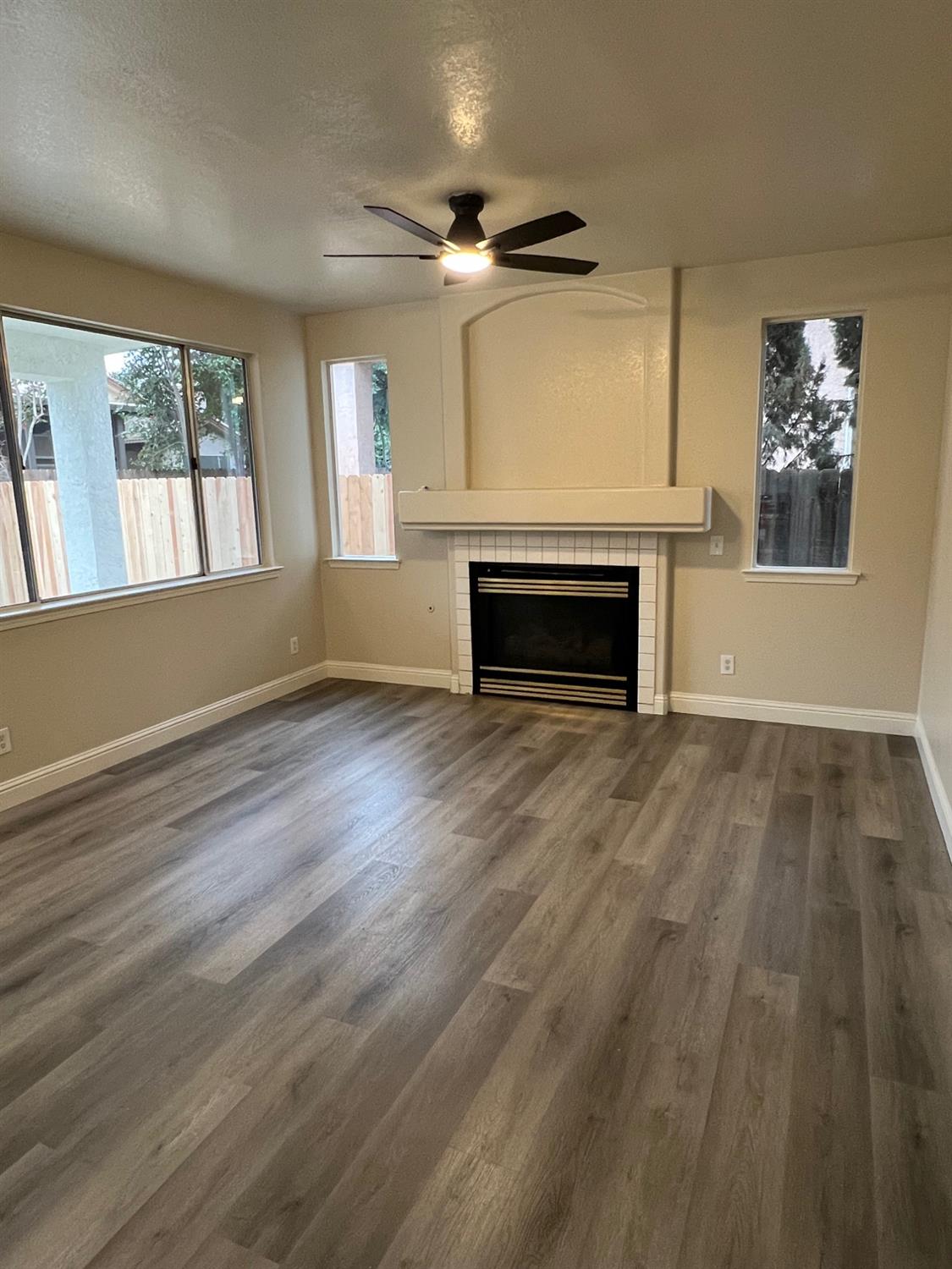 5930 West Birch Avenue Fresno, CA 93722 - Photo 7 of 32 wooden floor fireplace and windows in an empty room
