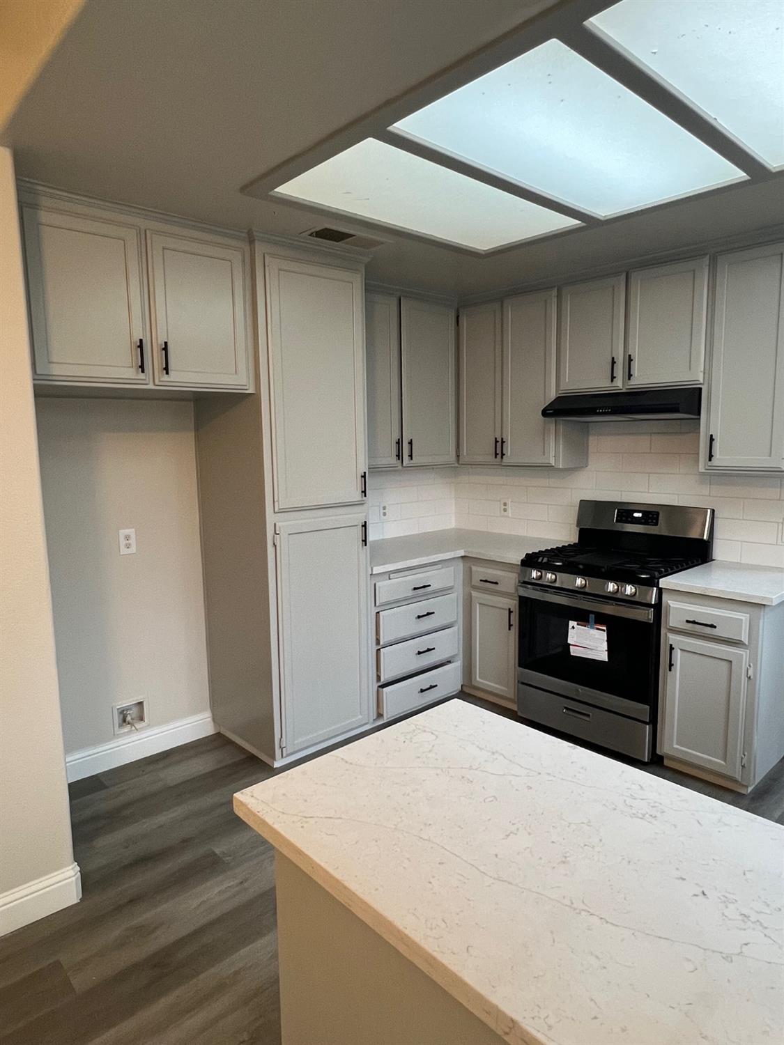 5930 West Birch Avenue Fresno, CA 93722 - Photo 9 of 32 a kitchen with granite countertop a stove and a refrigerator