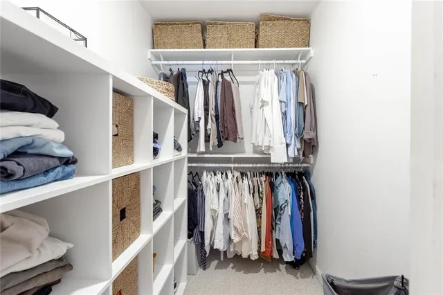 a view of walk in closet with clothes