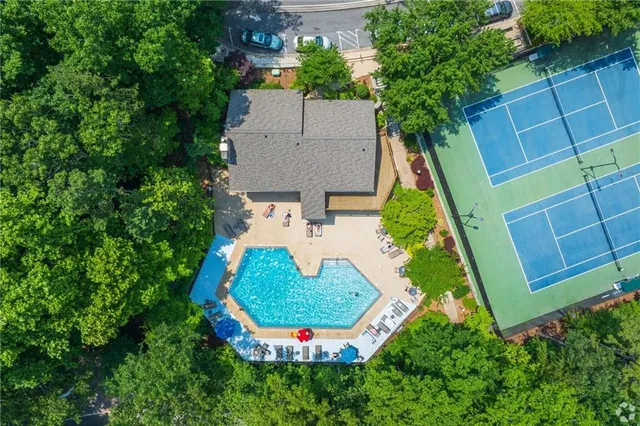 an aerial view of residential house with outdoor space and trees all around