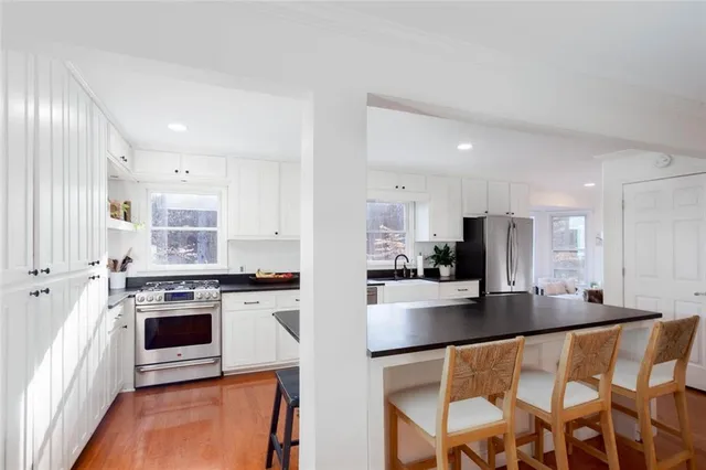 a kitchen with stainless steel appliances granite countertop a stove refrigerator and a sink