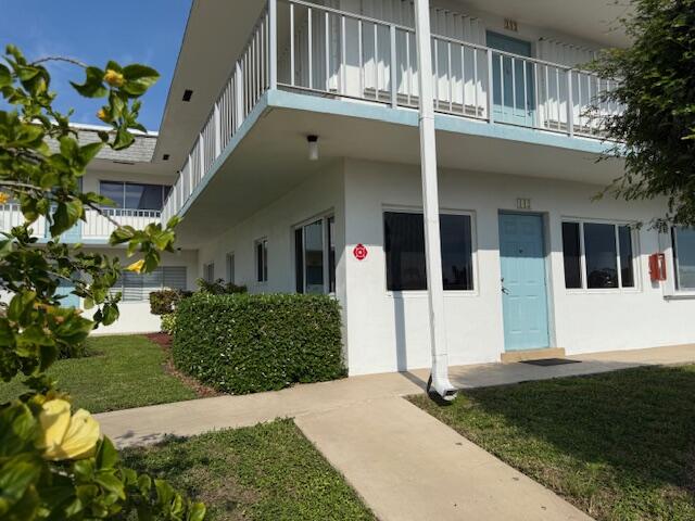 3402 Cynthia Lane, Unit 112 Lake Worth Beach, FL 33461 - Photo 30 of 41 a front view of a house with a garden