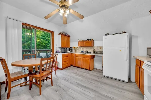 a dining room with furniture a kitchen view and a refrigerator