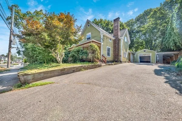 a view of house with yard and trees in front of it