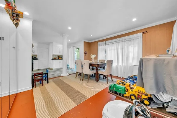 a living room with furniture a dining table and a refrigerator