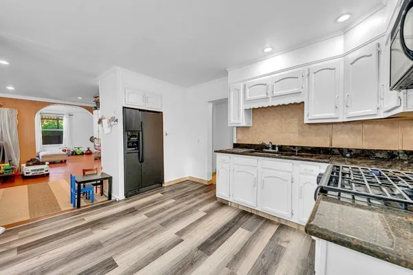 a kitchen with granite countertop a stove and cabinets