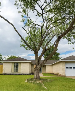 a front view of house with yard and trees around