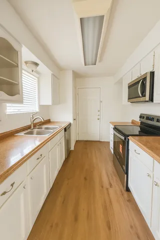 a kitchen with stainless steel appliances a sink stove and cabinets