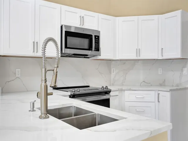 a kitchen with granite countertop a stove and a microwave