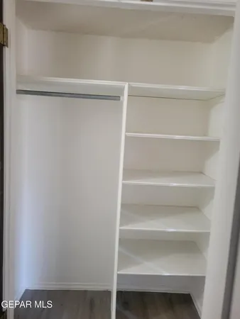 a view of walk in closet with empty racks