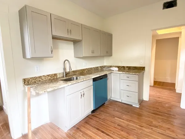 a kitchen with granite countertop a sink stainless steel appliances and cabinets
