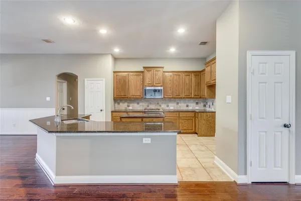 a kitchen with stainless steel appliances granite countertop a sink stove and cabinets