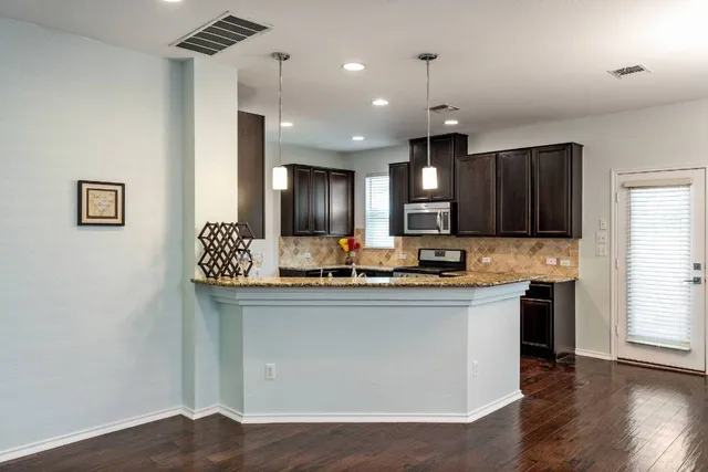 a kitchen with stainless steel appliances granite countertop a sink stove and wooden floor