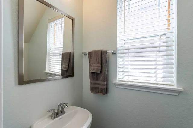a bathroom with a sink a mirror and a window