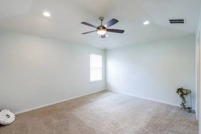 an empty room with windows and fan