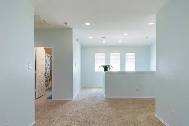 an empty room with windows and cabinet