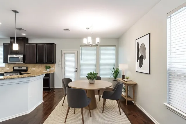 a kitchen with a dining table chairs and window