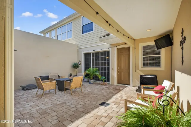 a view of a patio with table and chairs and potted plants