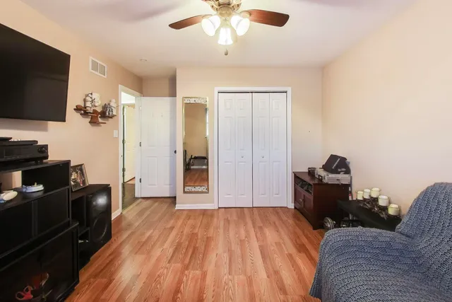 a living room with a bed furniture and a flat screen tv