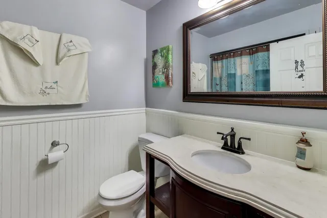 a bathroom with a toilet sink and mirror