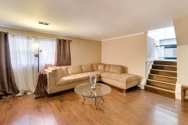 a living room with furniture and a wooden floor