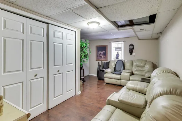 a living room with furniture a flat screen tv and a walk in closet