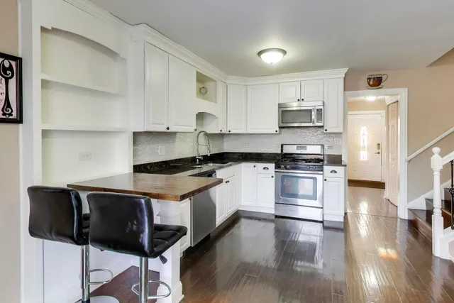 a kitchen with granite countertop white cabinets and black appliances