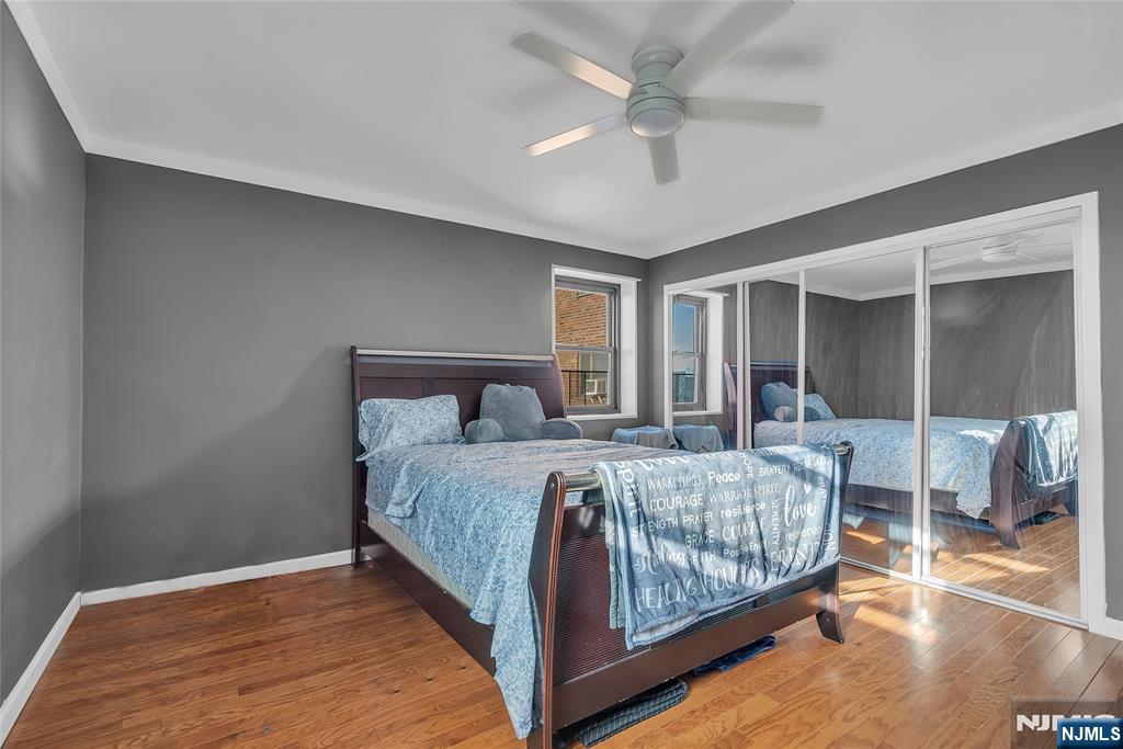 208 Anderson Street, Unit S4C Hackensack, NJ 07601 - Photo 11 of 17 a bedroom with a large bed and a chandelier