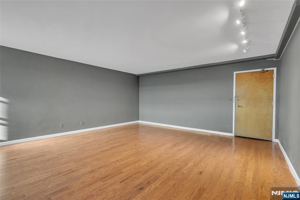 208 Anderson Street, Unit S4C Hackensack, NJ 07601 - Photo 7 of 17 a view of an empty room with wooden floor and a window