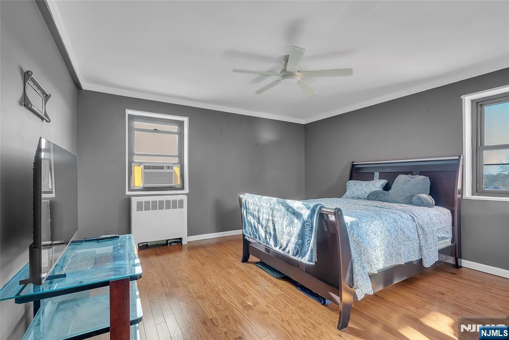 208 Anderson Street, Unit S4C Hackensack, NJ 07601 - Photo 10 of 17 a bedroom with a bed and a flat screen tv