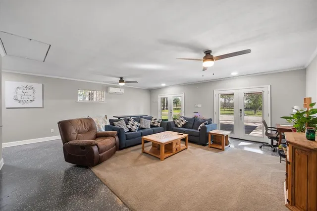a living room with furniture ceiling fan and a window