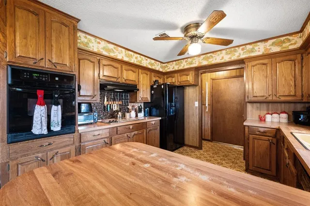 a kitchen with stainless steel appliances kitchen island granite countertop a refrigerator and a sink