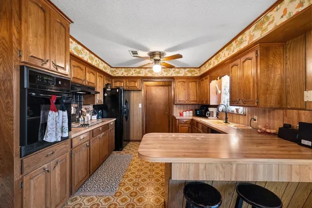 a large kitchen with stainless steel appliances granite countertop a large counter space and a stove
