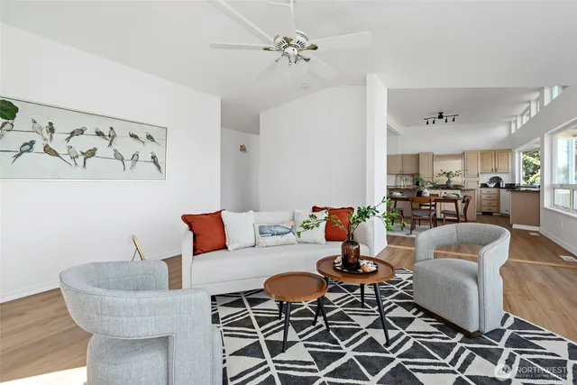a living room with furniture kitchen view and a chandelier