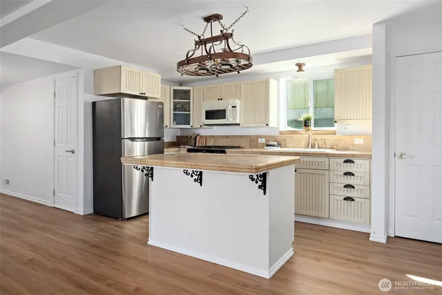 a kitchen with a refrigerator a sink and cabinets