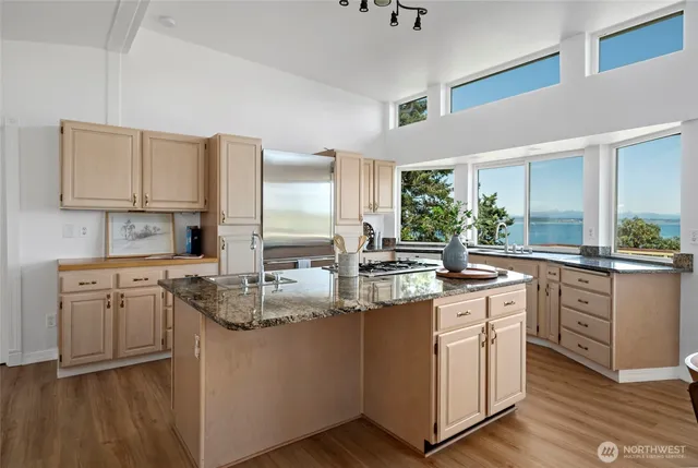 a kitchen with stainless steel appliances granite countertop a stove a sink dishwasher and a refrigerator