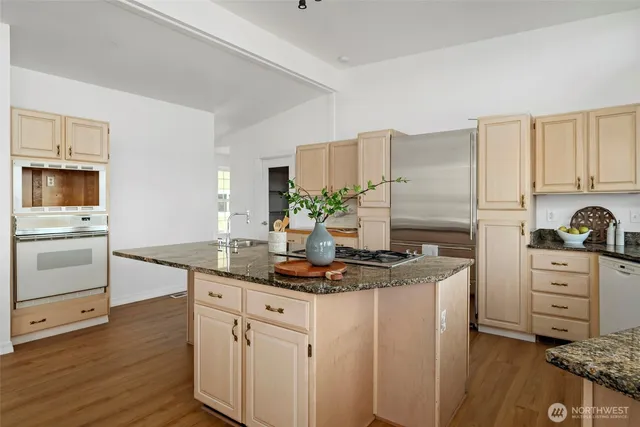a kitchen with stainless steel appliances granite countertop a stove a sink and white cabinets