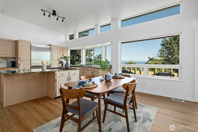 a dining room with furniture a large window and wooden floor