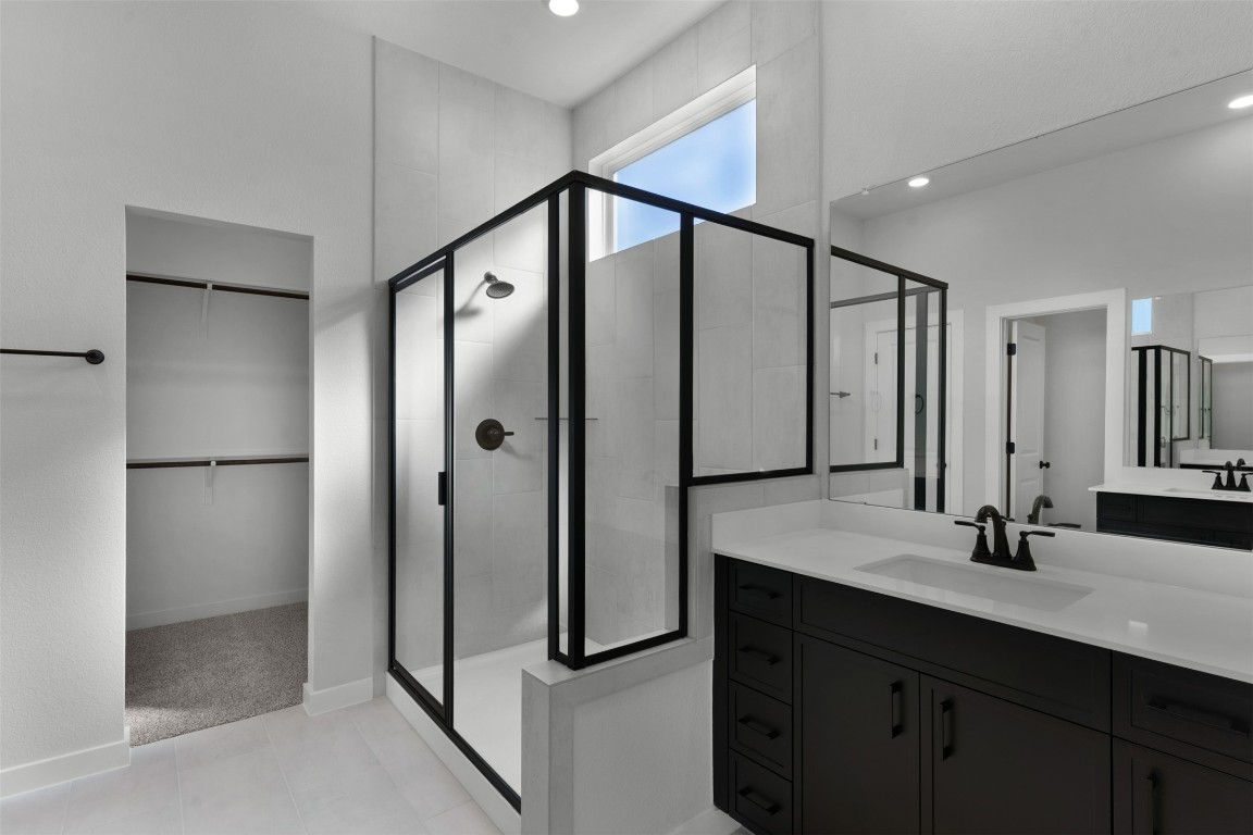 237 Wingstem Way Georgetown, TX 78633 - Photo 12 of 26 Bathroom featuring a walk in closet, vanity, a stall shower, and recessed lighting