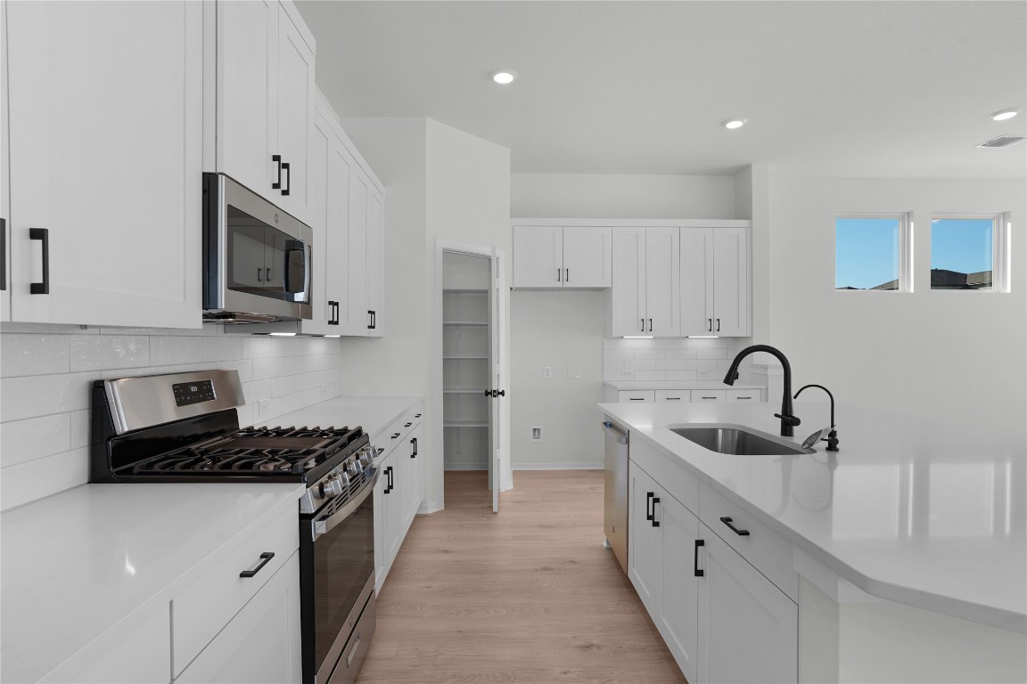 237 Wingstem Way Georgetown, TX 78633 - Photo 29 of 40 a kitchen with granite countertop a sink stainless steel appliances and cabinets