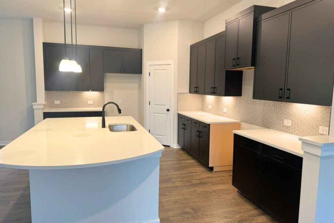 237 Wingstem Way Georgetown, TX 78633 - Photo 4 of 40 a kitchen with stainless steel appliances granite countertop a sink and a stove top oven