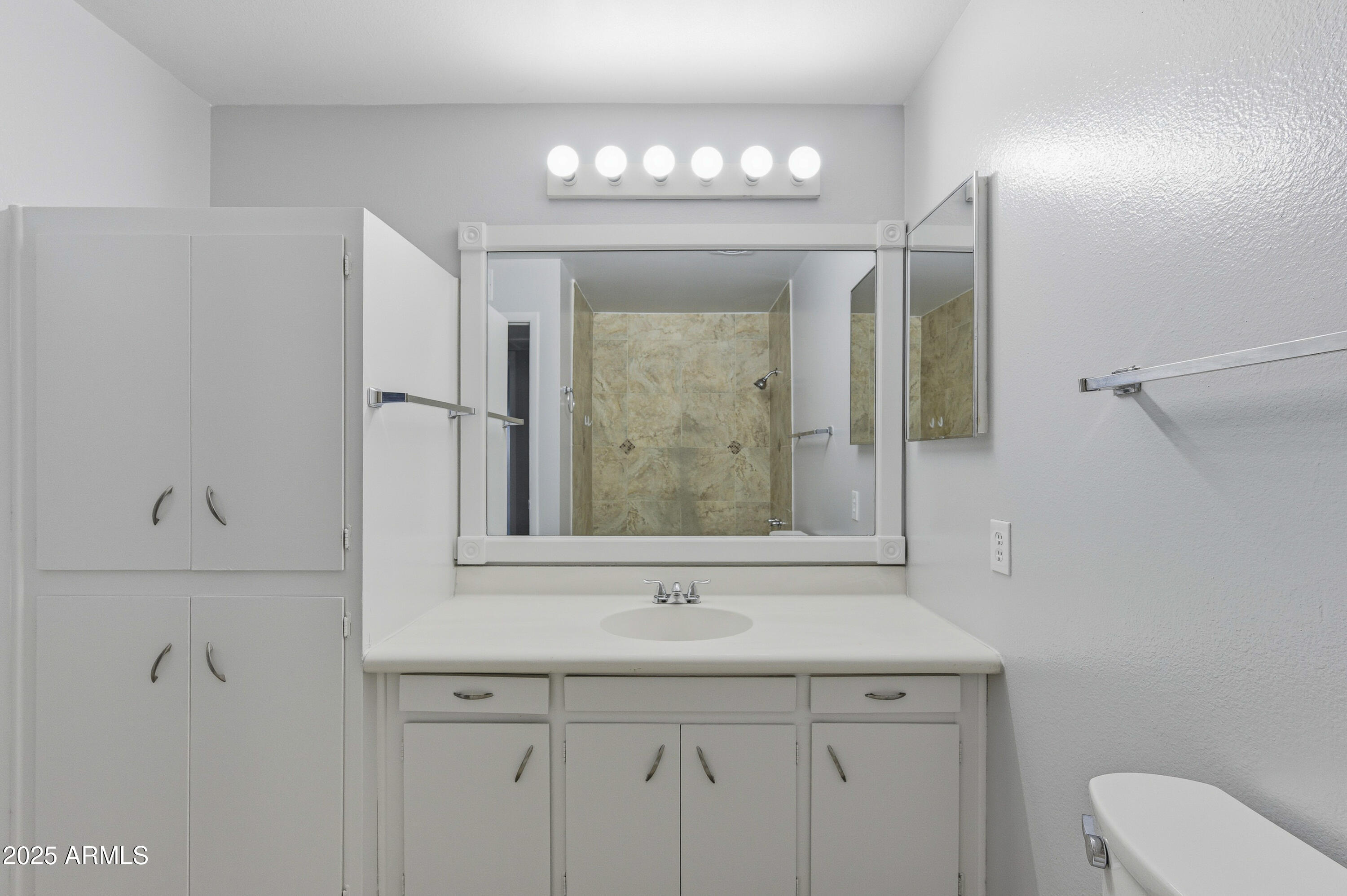 4808 North 71st Lane Phoenix, AZ 85033 - Photo 11 of 20 a bathroom with a sink a mirror and a vanity