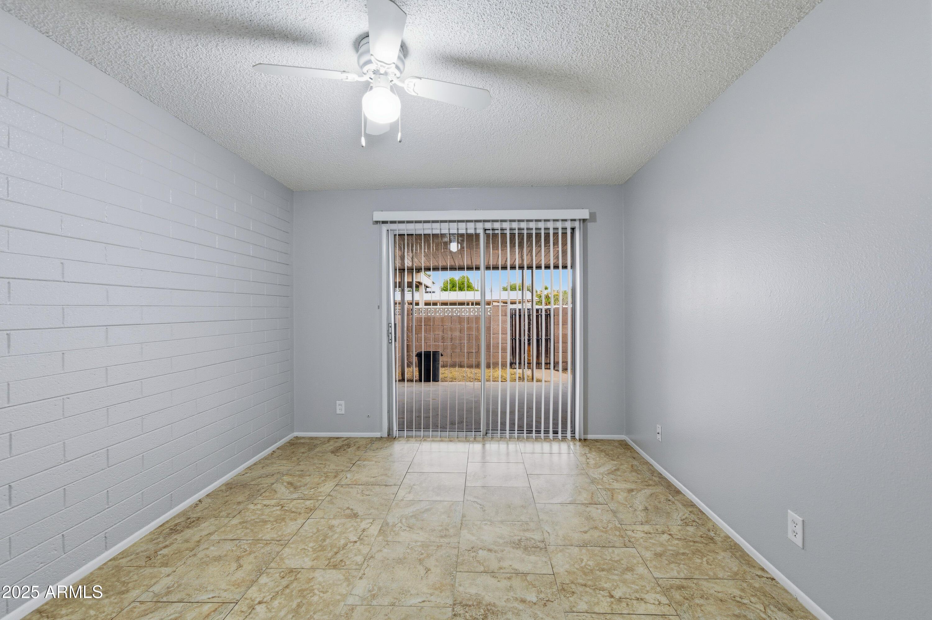 4808 North 71st Lane Phoenix, AZ 85033 - Photo 12 of 20 an empty room with a ceiling fan and windows