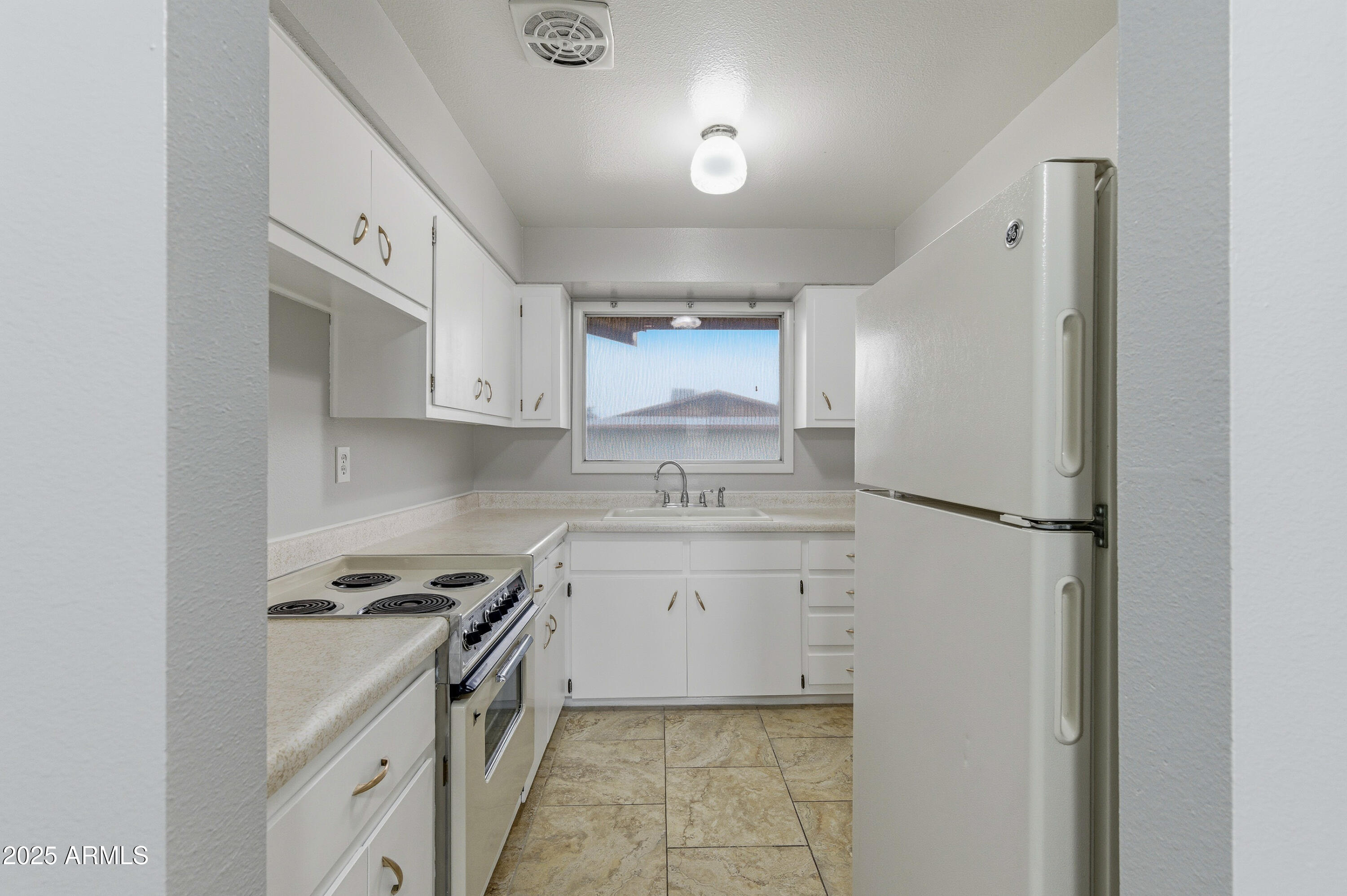 4808 North 71st Lane Phoenix, AZ 85033 - Photo 3 of 20 a kitchen with a sink stove and refrigerator