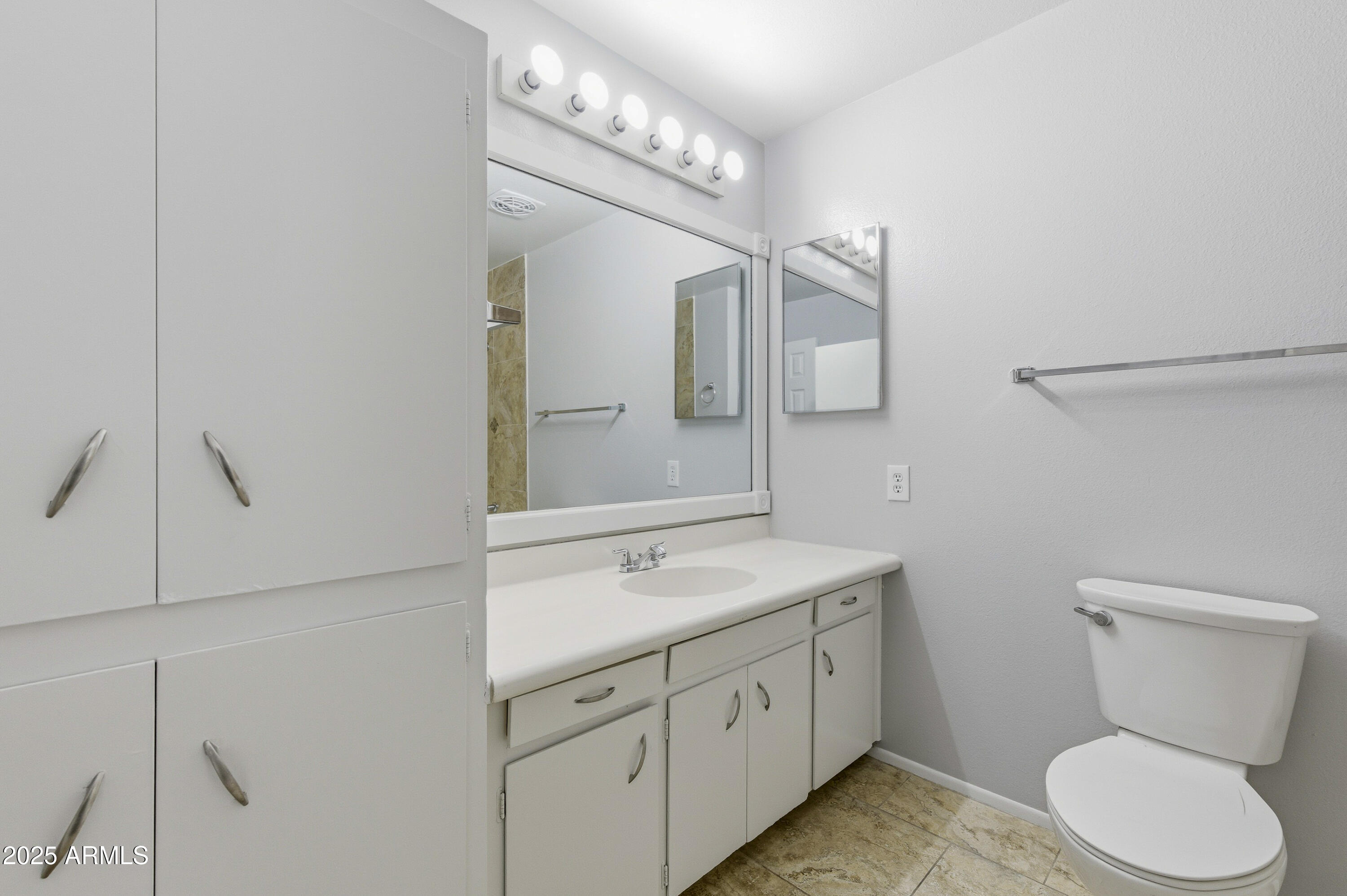 4808 North 71st Lane Phoenix, AZ 85033 - Photo 9 of 20 a bathroom with a toilet sink and mirror