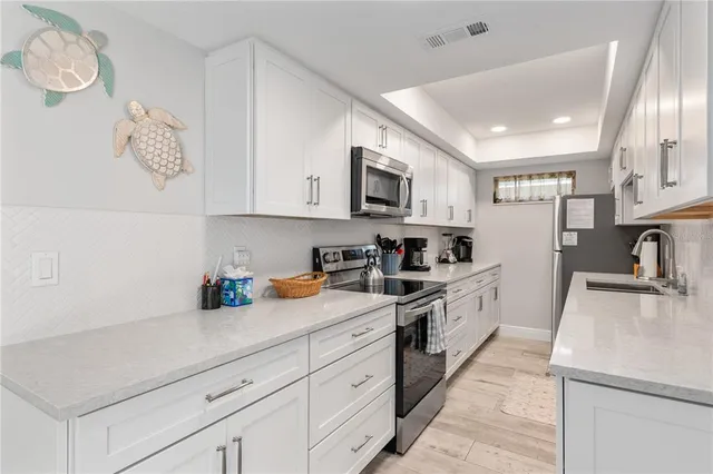 a kitchen with stainless steel appliances granite countertop a sink a stove and a refrigerator